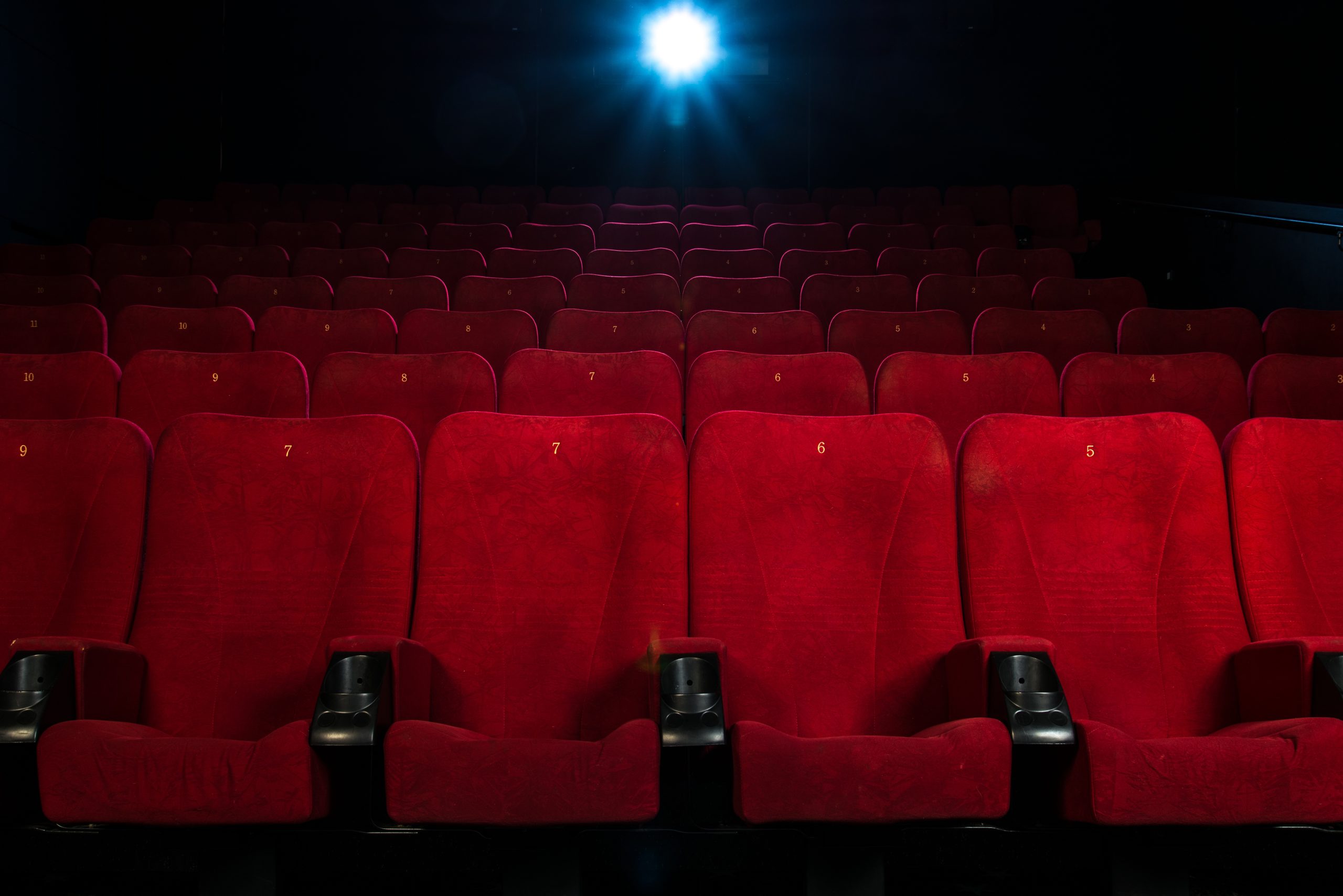 Empty comfortable red seats with numbers in cinema